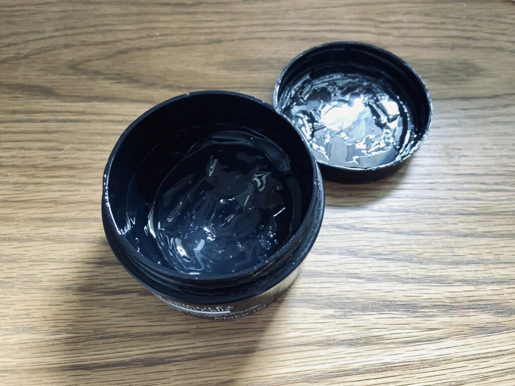 黒い容器の蓋が開いているジェルの画像
