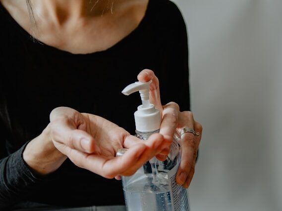 女性がポンプ式のジェルを押している画像
