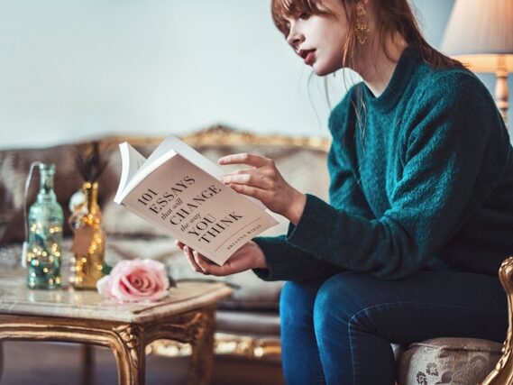 女性がソファに座って読書している画像