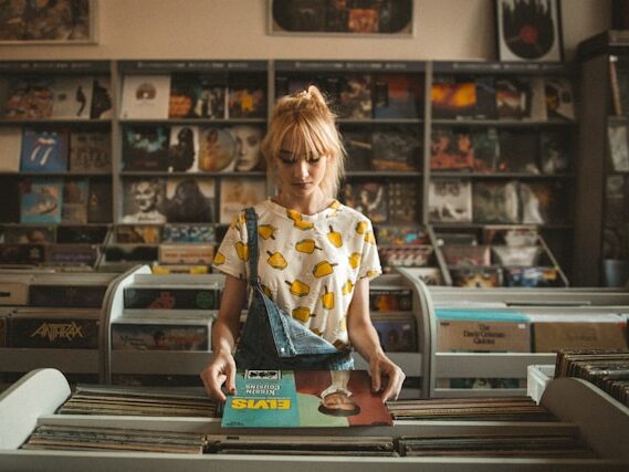 金髪の女性がレコード屋でレコードを見ている画像