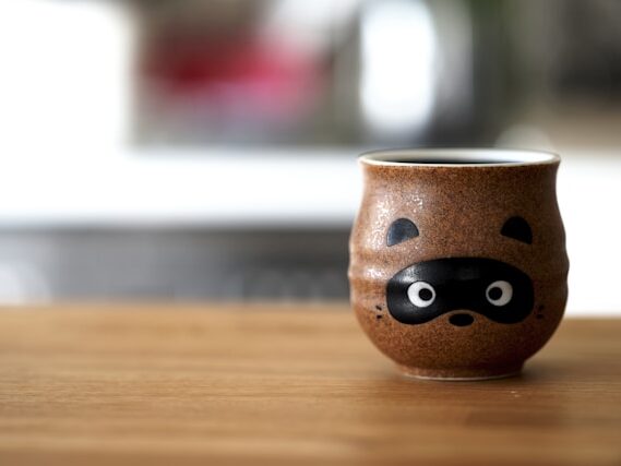 狸の顔が書いてある茶色い湯呑が置いてある画像