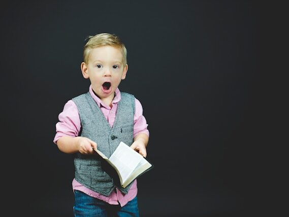 男の子が本を開いて、口を開けている画像