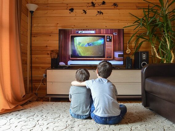 男の子二人が部屋で、肩を組んでテレビを見ている画像
