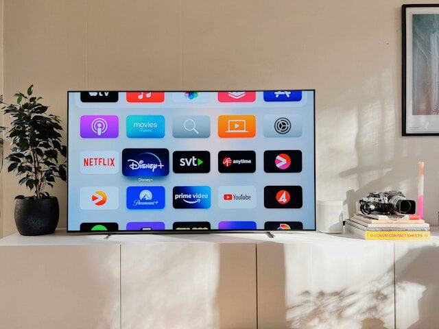 部屋においてあるテレビの画面に複数のアプリが表示されている画像