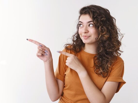 女性が右を両手で指さしている画像
