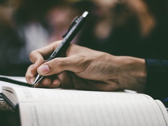 ボールペンでノートに書いている画像