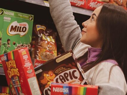 ショッピングセンターで沢山の箱をかかえている女性の画像