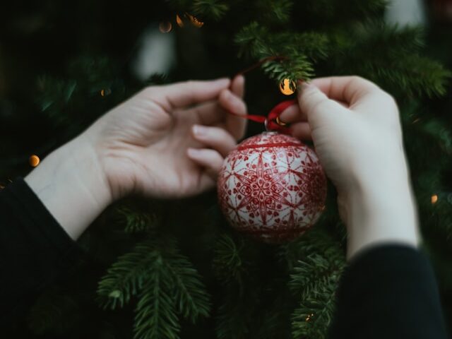 ツリーにオーナメントを付けている画像