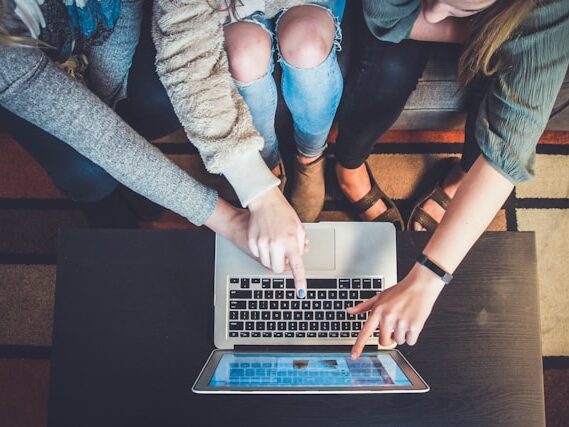 3人の女性がパソコンを見て指さしている画像