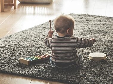 小さい男の子が楽器で遊んでいる画像