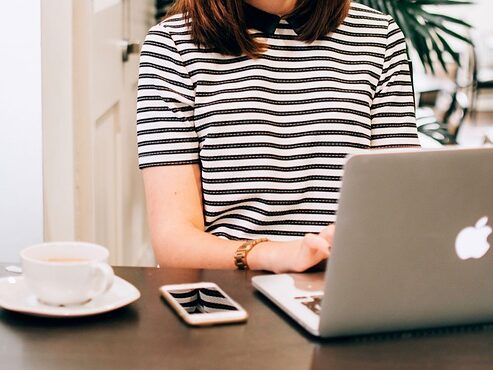 女性がパソコンの前に座っている画像