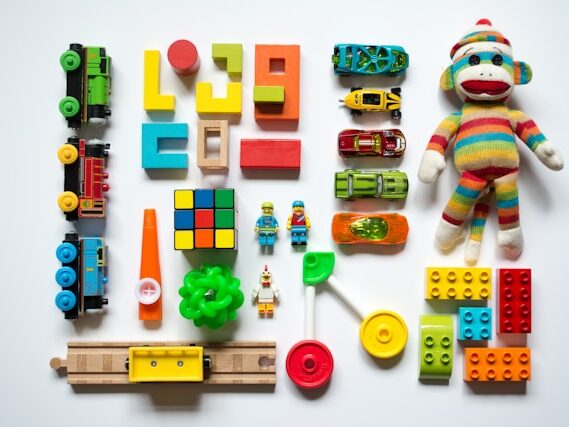 カラフルな車やブロック、ぬいぐるみなどのおもちゃが綺麗に並べてある画像