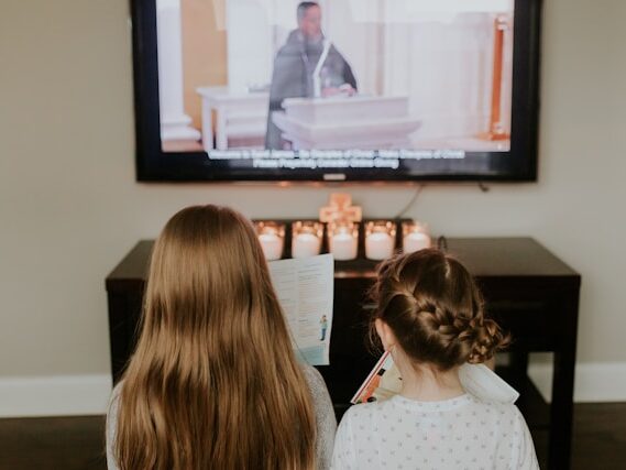 2人の少女が並んでテレビを観ている画像