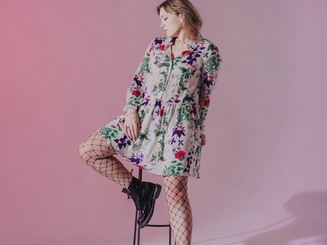 花柄話wンピースを着た女性が椅子に寄りかかって立っている画像