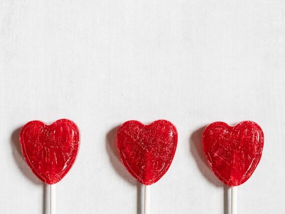 ハート型の赤いキャンディーポップが３つ並んでいる画像