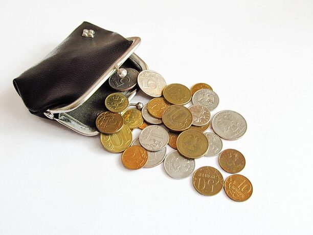 黒いがま口から小銭があふれている画像