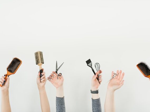 ハサミやブラシを持っている手をしたからン伸ばしている画像