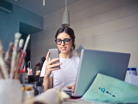 メガネをかけた女性が携帯をみている画像