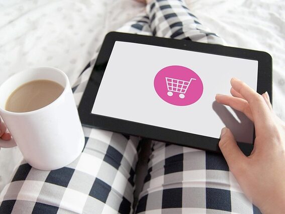 膝の上にタブレットを置いてネットショッピングしている画像