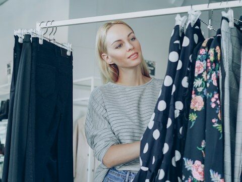 ブティックで服を選ぶ女性の画像
