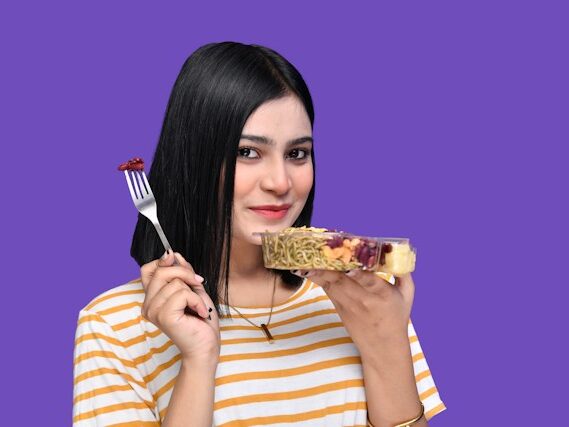 女性がフォークで食べている画像
