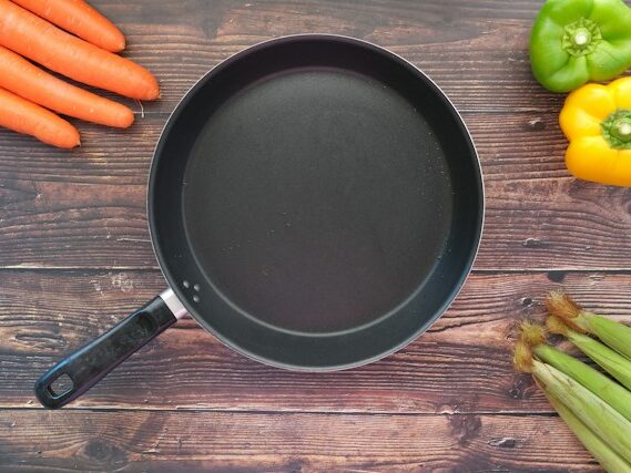 フライパンを囲んで野菜が置いてある画像
