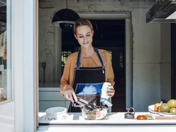 エプロンをした女性が料理をしている画像