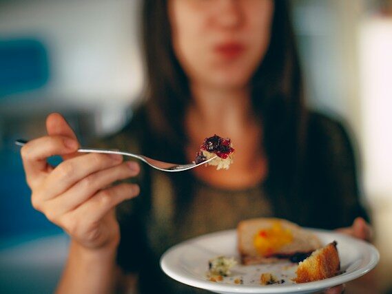 女性がフォークで食べている画像