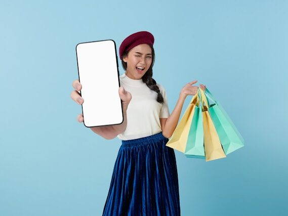 紙袋と携帯を持っている女性の画像