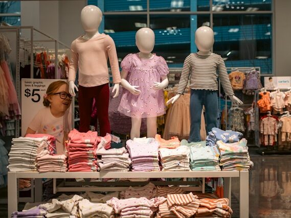 マネキンと一緒に陳列されて子供服の画像