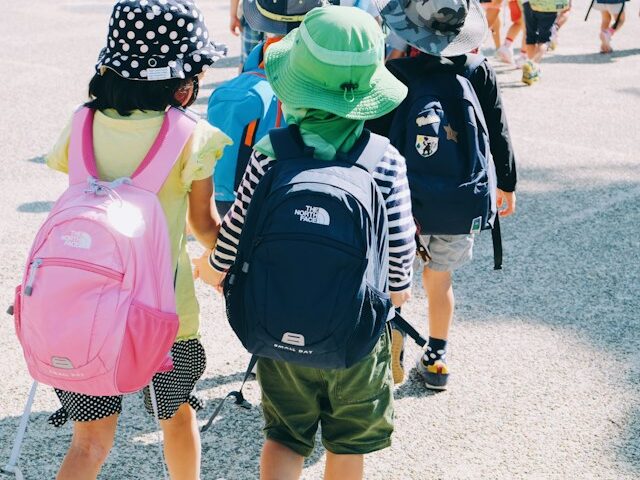 外で子どもたちがリュックサックを背負っている画像