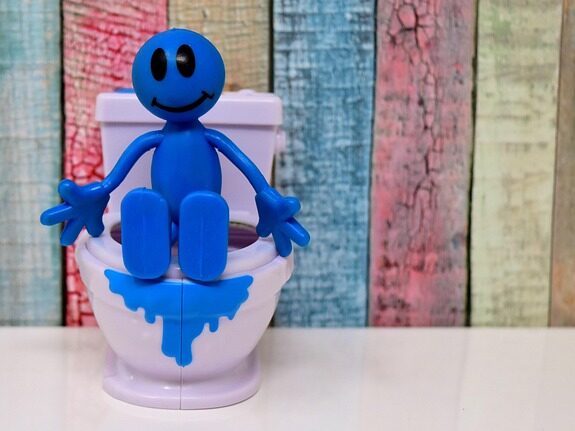 青い人形がおもちゃのトイレに座っている画像